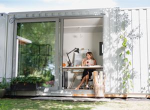 Woman Working In A Metal Outdoor Office Shed